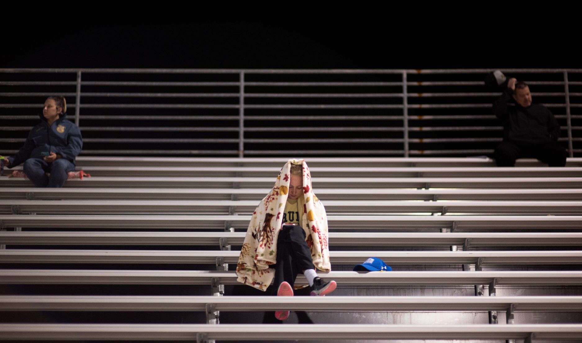 Rock Bridge senior Madison Snodderley sits socially distant during halftime intermission